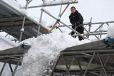 Oficiální doprovodný program má trochu starosti. Těžký sníh ohrožuje stabilitu montovaných konstrukcí. Zde jej technici shazují ze střechy pódia na Náměstí Eduarda Beneše.
