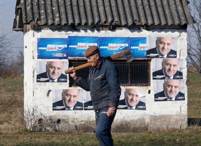 An elderly man passes by a shack pasted with pre-election posters of Serbia's ultra-nationalist Radical Party acting leader Tomislav Nikolic in the village of Jakovo, west from Belgrade January 16, 2008. Presidential elections in Serbia are scheduled for January 20. REUTERS/Ivan Milutinovic (SERBIA)