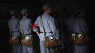 Mid-level government officials dressed in red army uniforms carry bags bearing an image of former Chinese leader Mao Zedong as they visit an old house where Mao used to live, during a five-day training course at the communist party school called China Executive Leadership Academy of Jinggangshan, in Jiangxi province, in this September 21, 2012 file photo. China's Communist Party has dramatically stepped up its training of the country's roughly 40 million party and government officials in the past decade. With public scrutiny of cadre behaviour growing via social media, the party is likely to call for continued, and deepened, cadre education at the upcoming 18th Party Congress. At the vanguard of this education drive, alongside a Central Party School in Beijing, are three "Executive Leadership Academies" which opened in 2005 for middle-ranking and senior officials in Shanghai, Yan'an and Jinggangshan. The curriculum covers Marxism, Leninism and Mao Zedong Thought, but students may also take finance courses, receive in-depth media training or role-play crisis management scenarios on everything from disease outbreaks to train wrecks. REUTERS/Carlos Barria/Files (CHINA - Tags: POLITICS SOCIETY) Published: Zář. 24, 2012, 2:09 odp.