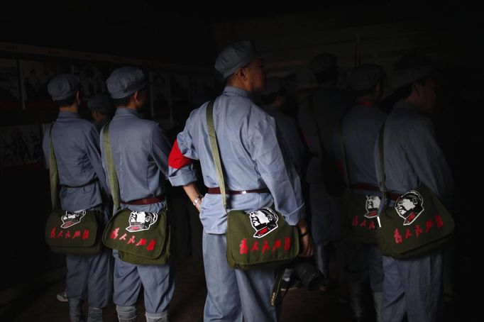 Mid-level government officials dressed in red army uniforms carry bags bearing an image of former Chinese leader Mao Zedong as they visit an old house where Mao used to live, during a five-day training course at the communist party school called China Executive Leadership Academy of Jinggangshan, in Jiangxi province, in this September 21, 2012 file photo. China's Communist Party has dramatically stepped up its training of the country's roughly 40 million party and government officials in the past decade. With public scrutiny of cadre behaviour growing via social media, the party is likely to call for continued, and deepened, cadre education at the upcoming 18th Party Congress. At the vanguard of this education drive, alongside a Central Party School in Beijing, are three "Executive Leadership Academies" which opened in 2005 for middle-ranking and senior officials in Shanghai, Yan'an and Jinggangshan. The curriculum covers Marxism, Leninism and Mao Zedong Thought, but students may also take finance courses, receive in-depth media training or role-play crisis management scenarios on everything from disease outbreaks to train wrecks. REUTERS/Carlos Barria/Files (CHINA - Tags: POLITICS SOCIETY) Published: Zář. 24, 2012, 2:09 odp.