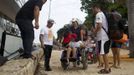 Marcilene Castro (3rd L) takes her daughter Alice, 17, who suffers from mild cerebral palsy, to board a boat in order to attend a "Bototherapy" session at Arau River in Amazon August 11, 2012. The "Bototherapy", a "Rolfing" therapeutic practice assisted by river dolphins, was developed by Igor Andrade, a physiotherapist, and the treatment is free for children with disabilities or disorders from low income families. Picture taken August 11, 2012. REUTERS/Bruno Kelly (BRAZIL - Tags: SOCIETY HEALTH) Published: Srp. 28, 2012, 1:55 dop.