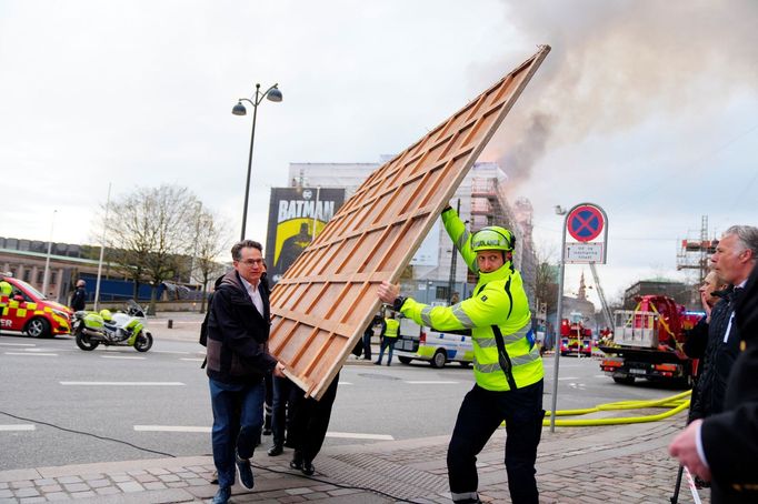 Lidé zachraňující obrazy z hořící budovy burzy v Kodani
