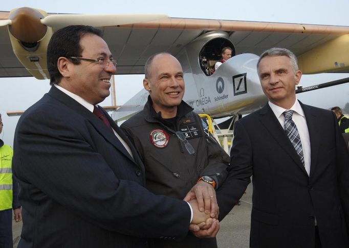 Solar Impulse project president and pilot Bertrand Piccard (C) shakes hands with Swiss Foreign Minister Didier Burkhalter (R) and Morocco ambassador Mohammed Said Benryane before take off at Payerne airport May 24, 2012. The Solar Impulse HB-SIA prototype aircraft, which has 12,000 solar cells built into its 64.3 metres (193 feet) wings, attempted its first intercontinental flight from Payerne to Rabat in Morocco with a few days for a technical stop and a change of pilot in Madrid. This flight will act as a final rehearsal for the 2014 round-the-world flight. REUTERS/Denis Balibouse (SWITZERLAND - Tags: TRANSPORT SCIENCE TECHNOLOGY SOCIETY POLITICS BUSINESS) Published: Kvě. 24, 2012, 7:48 dop.