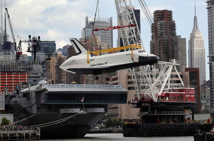 The Space Shuttle Enterprise is lifted onto the deck of the Intrepid Sea, Air and Space Museum on the retired USS Intrepid Aircraft carrier in New York June 6, 2012. REUTERS/Mike Segar (UNITED STATES - Tags: TRANSPORT SCIENCE TECHNOLOGY) Published: Čer. 6, 2012, 8:11 odp.