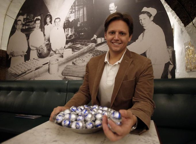 Owner Martin Fuerst poses with original Salzburger Mozartkugeln pralines in the confectionery 'Fuerst' in the Austrian city of Salzburg October 19, 2012. The confectionery Fuerst invented the original Salzburger Mozartskugeln, named after the famous composer Wolfgang Amadeus Mozart, in 1884 and still produces 2.5 million Mozartskugeln pralines per year exclusively by hand. REUTERS/Dominic Ebenbichler (AUSTRIA - Tags: FOOD SOCIETY) Published: Říj. 19, 2012, 3:57 odp.