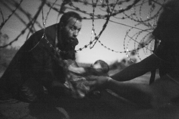 Soutěž World Press Photo vyhrál snímek kojence, kterého otec předává pod ostnatým drátem na hranici Srbska a Maďarska. Autorem je Australan Warren Richardson.