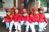 Děti v uniformách čekají na vztyčení čínské vlajky.