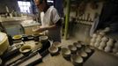 A worker removes bowls from a machine at the Middleport pottery in Stoke-on-Trent, central England January 22, 2013. The pottery which dates back to 1888 and was rescued from closure in 2009, continues to use traditional methods to produce its range of ceramics and famous Burleigh Ware pottery. REUTERS/Phil Noble (BRITAIN - Tags: BUSINESS EMPLOYMENT SOCIETY) Published: Led. 22, 2013, 5:39 odp.