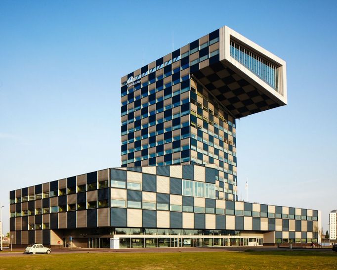 Neutelings/Shipping and Transport College, Rotterdam Budova Mezinárodní centra námořní školy připomínající periskop atomové ponorky kotvící v řece Maase. Skulpturální architektura s výjimečným prostorovým řešením, která se stala dominatou rotterdamského přístavu. Nadsázka, hravost, barevnost.