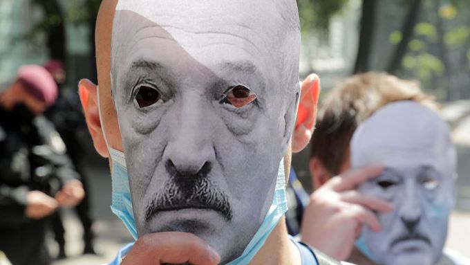 Demonstranti v Kyjevě drží papírové masky zobrazující běloruského prezidenta Alexandra Lukašenka.