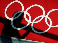 Stín rakouského skokana na lyžích Andrease Koflera dopadá na olympijské kruhy.