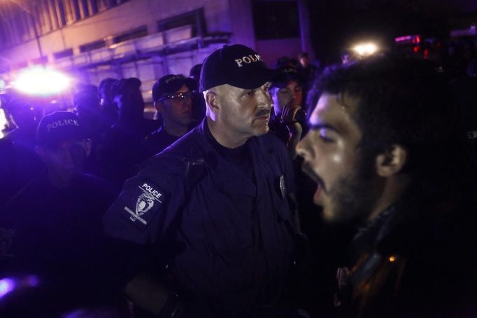 Police officers stand guard as a demonstrator shouts during a march on the first day of the Democratic National Convention in Charlotte, North Carolina, September 4, 2012. The demonstration was held to protest against capitalism. REUTERS/John Adkisson (UNITED STATES - Tags: CIVIL UNREST POLITICS TPX IMAGES OF THE DAY) Published: Zář. 5, 2012, 4:29 dop.