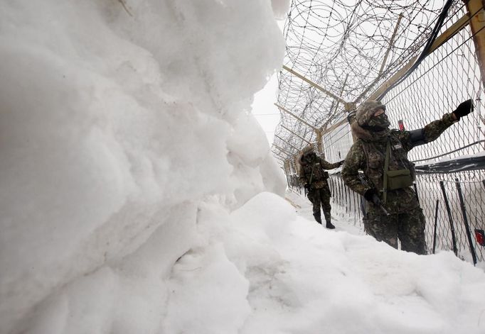 South Korean soldiers patrol along the military fence, just south of the demilitarized zone separating the two Koreas, in Yanggu, about 180 km (112 miles) northeast of Seoul February 6, 2013. New York under missile attack is a remote dream for impoverished North Korea, yet that is precisely what the latest propaganda video from the isolated state shows as it readies a third nuclear test. North Korea has trailed plans to carry out a third nuclear test, which experts believe is imminent. REUTERS/Lee Hae-yong/Yonhap (SOUTH KOREA - Tags: MILITARY POLITICS) NO SALES. NO ARCHIVES. SOUTH KOREA OUT. NO COMMERCIAL OR EDITORIAL SALES IN SOUTH KOREA. ATTENTION EDITORS - THIS IMAGE WAS PROVIDED BY A THIRD PARTY. FOR EDITORIAL USE ONLY. NOT FOR SALE FOR MARKETING OR ADVERTISING CAMPAIGNS. THIS PICTURE IS DISTRIBUTED EXACTLY AS RECEIVED BY REUTERS, AS A SERVICE TO CLIENTS Published: Úno. 6, 2013, 12:18 odp.