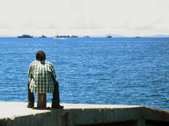 Odkud to přijde? Muž pozoruje lodě opuštějící přístav v Honiaře, hlavním městě Šalomounových ostrovů