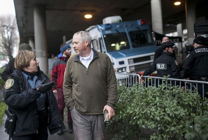 Seattle Mayor Mike McGinn talks with a Seattle Police Department Officer about the progress of a gun buyback event in Seattle, Washington January 26, 2013. Participants received up to a $100 gift card in exchange for working handguns, shotguns and rifles, and up to a $200 gift card for assault weapons. The event lasted from 9 a.m. until shortly after noon, after the event ran out of $80,000 worth of gift cards. REUTERS/Nick Adams (UNITED STATES - Tags: POLITICS CIVIL UNREST) Published: Led. 27, 2013, 2:31 dop.