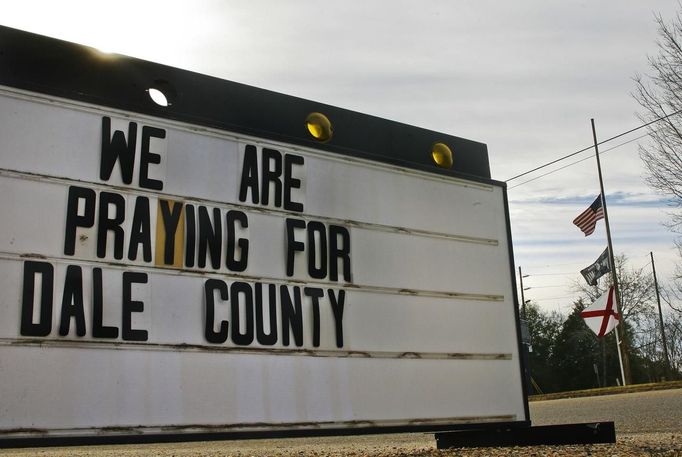 A sign in support of the victim and flags flying at half staff in Newton, near Midland City, Alabama February 1, 2013. Residents in a rural Alabama town prayed on Friday and called for the release of a 5-year-old boy being held captive for a fourth day by a man accused of shooting a school bus driver and then taking the child hostage. REUTERS/Phil Sears (UNITED STATES - Tags: CRIME LAW) Published: Úno. 1, 2013, 9:32 odp.