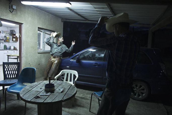 Israeli cowboys, Amit (L) and Alon (R), get ready in the early morning on a ranch just outside Moshav Yonatan, a collective farming community, about 2 km (1 mile) south of the ceasefire line between Israel and Syria in the Golan Heights May 21, 2013. Cowboys, who have been running the ranch on the Golan's volcanic rocky plateau for some 35 years, also host the Israeli military, who use half of the cattle farm, 20,000 dunams (5,000 acres), as a live-fire training zone. Israel captured the Golan Heights from Syria in the 1967 Middle East war and annexed the territory in 1981, a move not recognized internationally. Picture taken May 21, 2013. REUTERS/Nir Elias (ENVIRONMENT ANIMALS SOCIETY TPX IMAGES OF THE DAY) ATTENTION EDITORS: PICTURE 26 OF 27 FOR PACKAGE 'COWBOYS OF GOLAN HEIGHTS' SEARCH 'COWBOY GOLAN' FOR ALL IMAGES Published: Kvě. 29, 2013, 10:08 dop.