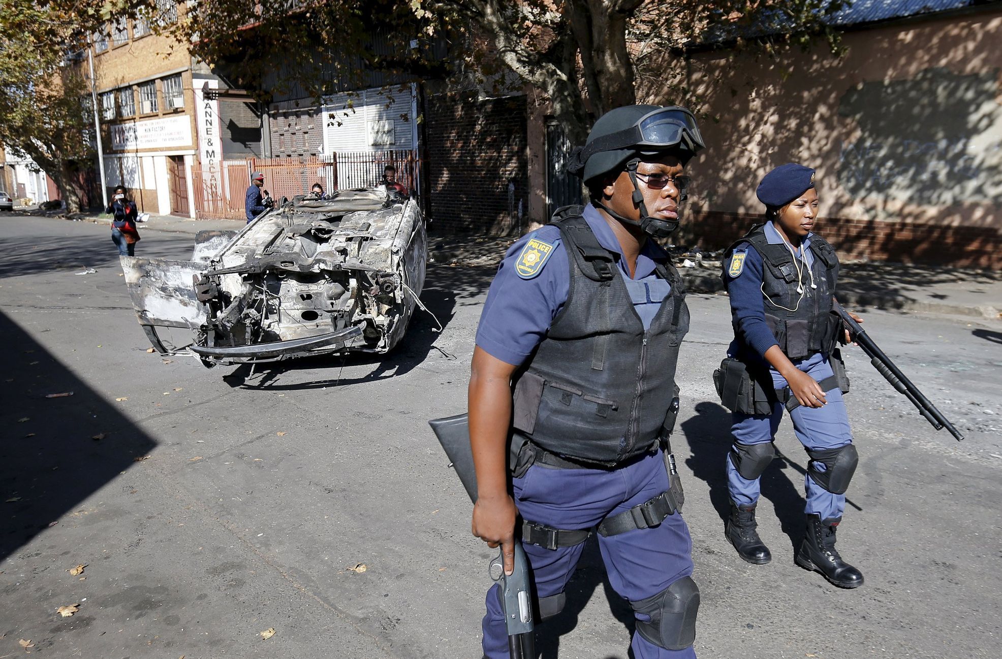 Jihoafrická policie u vraku auta, které shořelo přinepokojích v Johannesburgu.