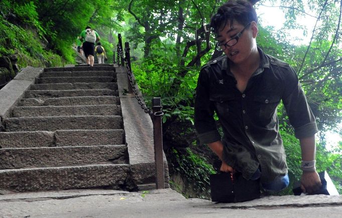 HUAYIN, CHINA - AUGUST 13: (CHINA OUT) Legless man Chen Zhou climbs the Huashan Mountain on August 13, 2012 in Huayin, Shaanxi Province of China. Legless 29-year-old man Chen Zhou from Cangshan of Shandong Province spent two days, 19 hours in total, climbing by arms to the top of Huashan Mountain. Chen lost his legs after falling off a train at the age of 13, but he has since strived to be stronger and joined in many public performances to encourage other people. Chen Zhou will climb the Taishan Mountain in Shandong province in the following months. ( automatický překlad do češtiny )