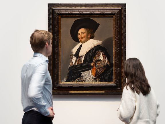 Návštěvníci výstavy si prohlížejí obraz Smějící se kavalír od Franse Halse z roku 1624.
