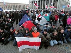 Demonstranti v úterý ráno na Říjnovém náměstí v Minsku. Příznivci opozice mají "své" běloruské vlajky. Oficiální běloruská vlajka je zelenočervená - stejná, jako ta z dob Sovětského svazu