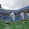 Pořadatelé uklízejí vodu po dešti na US Open 2012.