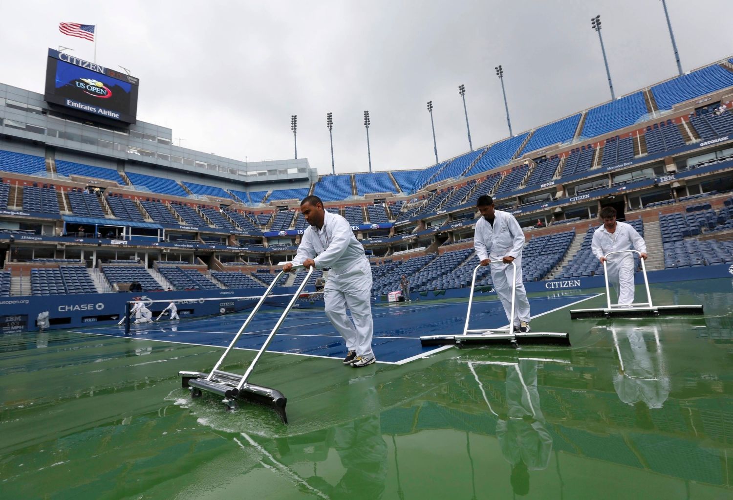 Pořadatelé uklízejí vodu po dešti na US Open 2012.