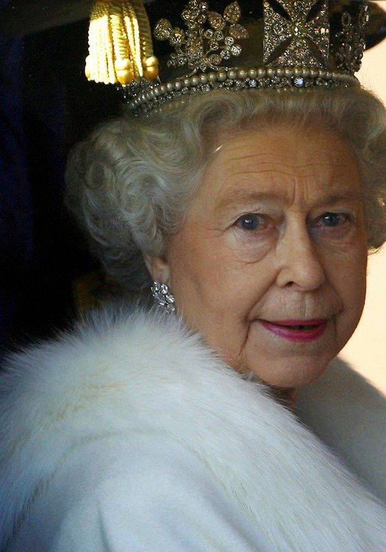 Královna Alžběta vyhlíží z kočáru