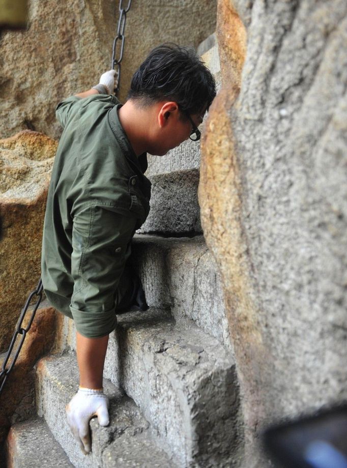 HUAYIN, CHINA - AUGUST 13: (CHINA OUT) Legless man Chen Zhou climbs the Huashan Mountain on August 13, 2012 in Huayin, Shaanxi Province of China. Legless 29-year-old man Chen Zhou from Cangshan of Shandong Province spent two days, 19 hours in total, climbing by arms to the top of Huashan Mountain. Chen lost his legs after falling off a train at the age of 13, but he has since strived to be stronger and joined in many public performances to encourage other people. Chen Zhou will climb the Taishan Mountain in Shandong province in the following months. ( automatický překlad do češtiny)