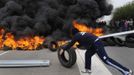 A striking coal miner places a tyre onto a barricade on the A-6 motorway, on the second day of a strike to protest the government's spending cuts in the mining sector, in El Montico, near Oviedo, northern Spain, May 24, 2012. Spain's economy is contracting for the second time since late 2009 and four years of stagnation and recession have pushed unemployment above 24 percent, the highest rate in the European Union. REUTERS/Eloy Alonso (SPAIN - Tags: CIVIL UNREST BUSINESS EMPLOYMENT ENERGY) Published: Kvě. 24, 2012, 10:08 dop.