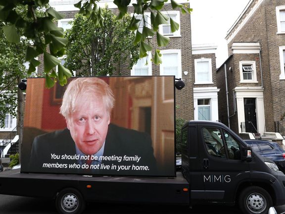 Protest u Cummingsova domu: obrazovka s projevem premiéra Johnsona, ve kterém lidi vyzývá, aby se během koronakrize nesetkávali s rodinou.
