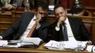 Greece's Finance Minister Yannis Stournaras (R) talks with Labour Minister Yannis Vroutsis during a parliament session in Athens November 7, 2012. The Greek government overcame divisions on Wednesday to defeat an early challenge to an austerity package needed to secure vital international aid, but it still faced internal dissent and angry protests ahead of a final vote. REUTERS/Yorgos Karahalis (GREECE - Tags: POLITICS BUSINESS)