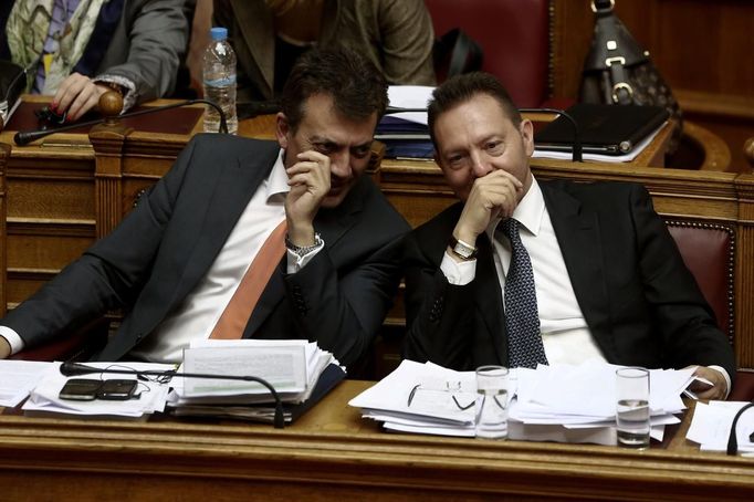 Greece's Finance Minister Yannis Stournaras (R) talks with Labour Minister Yannis Vroutsis during a parliament session in Athens November 7, 2012. The Greek government overcame divisions on Wednesday to defeat an early challenge to an austerity package needed to secure vital international aid, but it still faced internal dissent and angry protests ahead of a final vote. REUTERS/Yorgos Karahalis (GREECE - Tags: POLITICS BUSINESS)