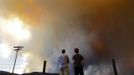 Robby Wood (L) of Denver, Colorado and his 16-year-old nephew Jacob Wood also of Denver, Colorado watch as smoke and flames encroach upon homes and ranches on the eastern front of the High Park Fire near Laporte, Colorado June 10, 2012. The fire started on Saturday and was estimated at more than 14,000 acres on Sunday morning. At least 18 structures were lost or damaged due to the fire with more threatened and officials are searching for one person believed to be missing. The cause of the fire is unknown and it remains at zero percent containment. REUTERS/Marc Piscotty (UNITED STATES - Tags: DISASTER ENVIRONMENT SOCIETY) Published: Čer. 11, 2012, 12:07 dop.