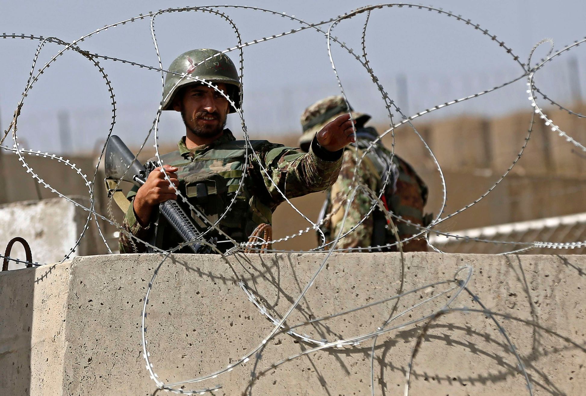Afghan National Army soldier keeps watch at gate of a British-run military training academy Camp Qargha, in Kabul