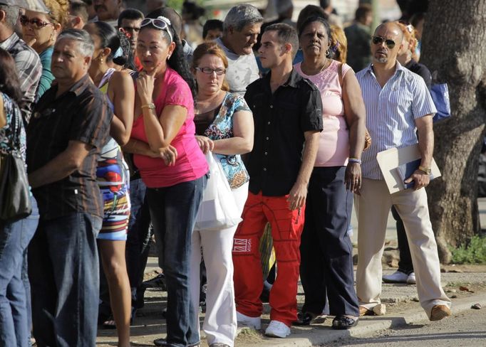 Luis Salgado, nicknamed Chucho, (in red pants) waits in line with other Cubans to pick up his visa at the U.S. Interests Section in Havana, February 25, 2013. Chucho's visa application, based on his father's status as legal resident in the U.S., was approved and he was reunited in Miami with his father, Jesus Salgado, who had escaped Cuba on a frail boat ten years earlier. The Salgados are among many Cubans taking advantage of Cuba's new travel policy in place since last January, which allows citizens to leave the country with just a passport and no need for much-hated exit visas required since 1961. Picture taken February 25, 2013. REUTERS/Desmond Boylan (CUBA - Tags: POLITICS SOCIETY) Published: Dub. 11, 2013, 2:10 odp.