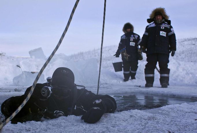 Alexander Gubin, 43, prepares to dive into the frozen Labynkyr lake, some 100 km south from Oymyakon in the Republic of Sakha, northeast Russia, February 1, 2013. The coldest temperatures in the northern hemisphere have been recorded in Sakha, the location of the Oymyakon valley, where according to the United Kingdom Met Office a temperature of -67.8 degrees Celsius (-90 degrees Fahrenheit) was registered in 1933 - the coldest on record in the northern hemisphere since the beginning of the 20th century. Yet despite the harsh climate, people live in the valley, and the area is equipped with schools, a post office, a bank, and even an airport runway (albeit open only in the summer). Picture taken February 1, 2013. REUTERS/Maxim Shemetov (RUSSIA - Tags: SOCIETY TPX IMAGES OF THE DAY ENVIRONMENT) ATTENTION EDITORS: PICTURE 19 OF 27 FOR PACKAGE 'THE POLE OF COLD' SEARCH 'MAXIM COLD' FOR ALL IMAGES Published: Úno. 18, 2013, 11:26 dop.