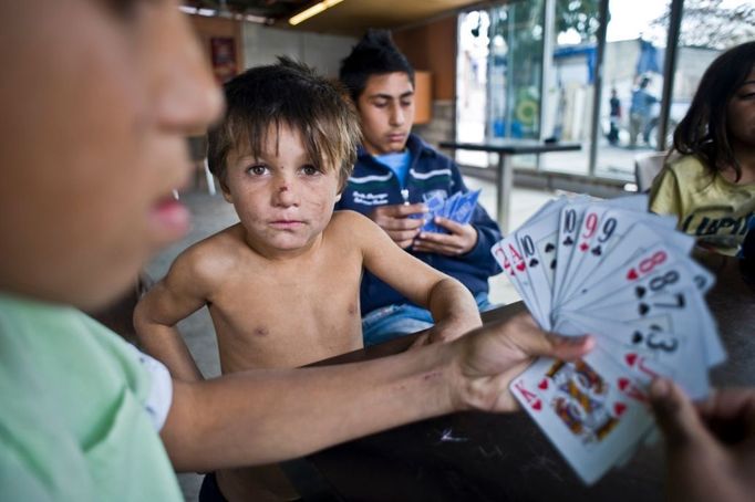 30 Titulek: Albanian gypsies face poverty in Greece Popis: October 26, 2011, Athens, Greece: October 26, 2011 - Athens, Greece: Children play cards in the slum's coffee shop. Majority of migrant Albanian gypsy families use tourist visa in order to live in Greece, which they renew every six months, otherwise they become illegal. Gypsies' relocation from this Botanikos' private and by force occupied land to another place in order to find clean water, sanitary and schools, seems impossible due to Greek crisis. Gypsies below Acropolis' slum survive by selling scrap or by stealing. (Maro Kouri / Polaris). In October 2013, an unidentified girl, called "Maria," was found in a Greek gypsy camp and could be related to missing child cases. Over 8,000 calls about the girl from all over the world including the U.S. and Canada have been received inquiring about the child. The blond girl, approximately age 4, was found in a Roma gypsy settlement in central Greece. DNA tests proved that she was not related to the 39-year-old man and 40-year-old woman who claimed to be her parents.