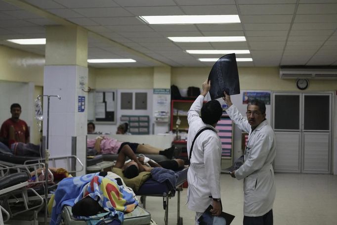 Doctors look at an x-ray at the emergency ward of a local hospital in San Pedro Sula March 28, 2013. San Pedro Sula, the country's second largest city after Tegucigalpa, has a homicide rate of 169 per 100,000 people and was named the world's most violent city for a second year in a row. Lax laws allow civilians to own up to five personal guns. Arms trafficking has flooded the country with nearly 70% illegal firearms. 83.4% of homicides are by firearms, compared to 60% in the United States. Picture taken March 28, 2013. REUTERS/Jorge Cabrera (HONDURAS - Tags: CRIME LAW CIVIL UNREST HEALTH) ATTENTION EDITORS: PICTURE 21 OF 39 FOR PACKAGE 'GUN CULTURE - HONDURAS' SEARCH 'HONDURAS GUN' FOR ALL IMAGES Published: Dub. 5, 2013, 11:15 dop.