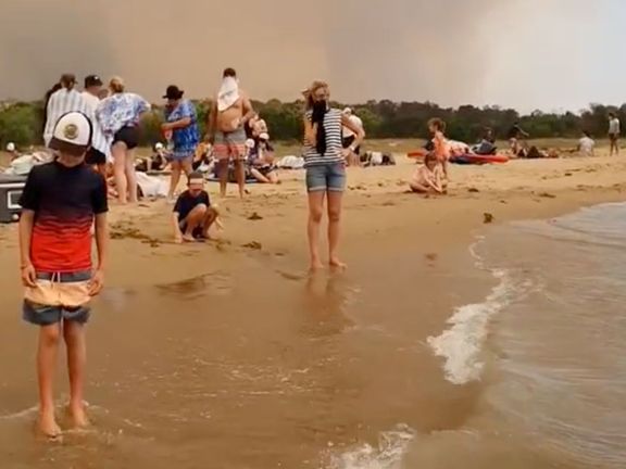 Davy lidí na pláži u Batemans Bay v Austrálii, kam utekli před požáry
