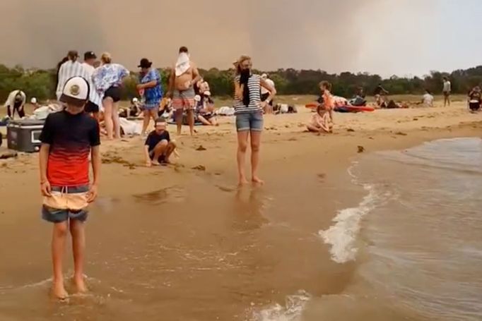 Davy lidí na pláži u Batemans Bay v Austrálii, kam utekli před požáry