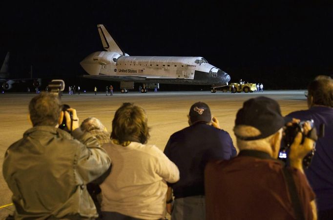 People take photos as the space shuttle Discovery is being towed for the last time out of the Vehicle Assembly Building to the Mate Demate Facility at Kennedy Space Center