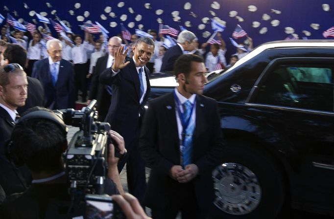 U.S. President Barack Obama (C) waves as he leaves the residence of Israel's President Shimon Peres in Jerusalem March 20, 2013. Making his first official visit to Israel, Obama pledged on Wednesday unwavering commitment to the security of the Jewish State where concern over a nuclear-armed Iran has clouded U.S.-Israeli relations. REUTERS/Ronen Zvulun (JERUSALEM - Tags: POLITICS) Published: Bře. 20, 2013, 4:06 odp.