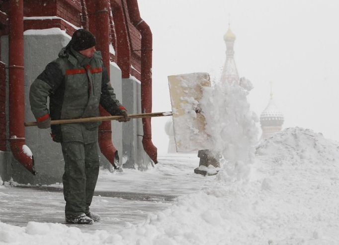 A worker removes snow near Red Square, with St. Basil's Cathedral seen in the background, during heavy snowfall in central Moscow, November 29, 2012. REUTERS/Sergei Karpukhin (RUSSIA - Tags: ENVIRONMENT CITYSPACE) Published: Lis. 29, 2012, 11:35 dop.