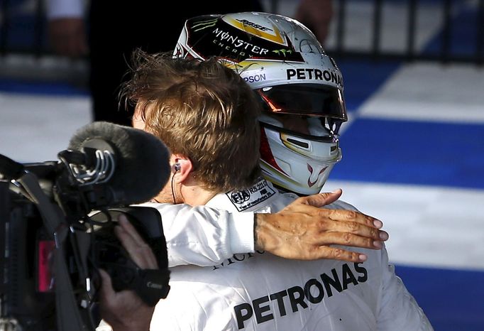 Mercedes F1 driver Nico Rosberg (R) is hugged by team mate Lewis Hamilton after winning the Australian Formula One Grand Prix in Melbourne