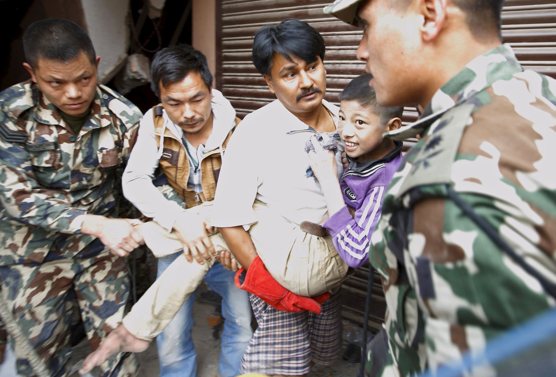 Boy smiles as he is rescued from a collapsed house after a 7.9 magnitude earthquake hit, in Kathmandu, Nepal