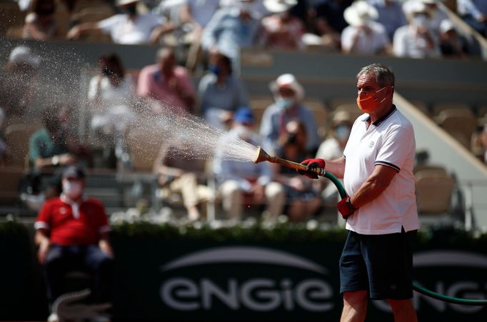 Správce zavlažuje kurt vodou během finále French Open mezi Barborou Krejčíkovou a Anastasií Pavljučenkovovou