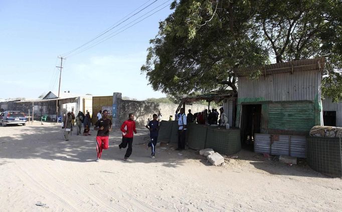 Somali athletes run past a police roadblock along a street in Hodan district as they train during preparations for the 2012 London Olympic Games in Somalia's capital Mogadishu March 14, 2012 file photos. Training in a bullet-riddled stadium where the remains of a rocket propelled grenade lies discarded on the track's edge counts as progress for Somali Olympic hopeful Mohamed Hassan Mohamed. A year ago, Mogadishu's Konis stadium was a base for Islamist militants and a work out meant at times running through the streets, dodging gun-fire and mortar shells in one of the world's most dangerous cities. To match OLY-SOMALIA-HOPES/ REUTERS/Feisal Omar/Files (SOMALIA - Tags: SPORT ATHLETICS SOCIETY OLYMPICS) Published: Čer. 11, 2012, 6:57 dop.