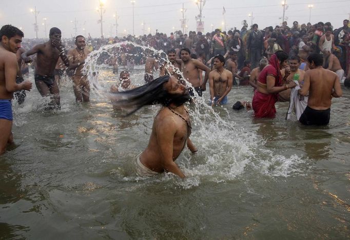 Hindu devotees take dip during the first "Shahi Snan" (grand bath) at the ongoing "Kumbh Mela", or Pitcher Festival, in the northern Indian city of Allahabad January 14, 2013. Upwards of a million elated Hindu holy men and pilgrims took a bracing plunge in India's sacred Ganges river to wash away lifetimes of sins on Monday, in a raucous start to an ever-growing religious gathering that is already the world's largest. REUTERS/Jitendra Prakash (INDIA - Tags: RELIGION SOCIETY) Published: Led. 14, 2013, 12:11 odp.