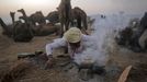 A camel herder lights a fire to cook on at Pushkar Fair in the desert Indian state of Rajasthan November 23, 2012. Many international and domestic tourists throng to Pushkar to witness one of the most colourful and popular fairs in India. Thousands of animals, mainly camels, are brought to the fair to be sold and traded. REUTERS/Danish Siddiqui (INDIA - Tags: SOCIETY ANIMALS) Published: Lis. 23, 2012, 5:38 odp.